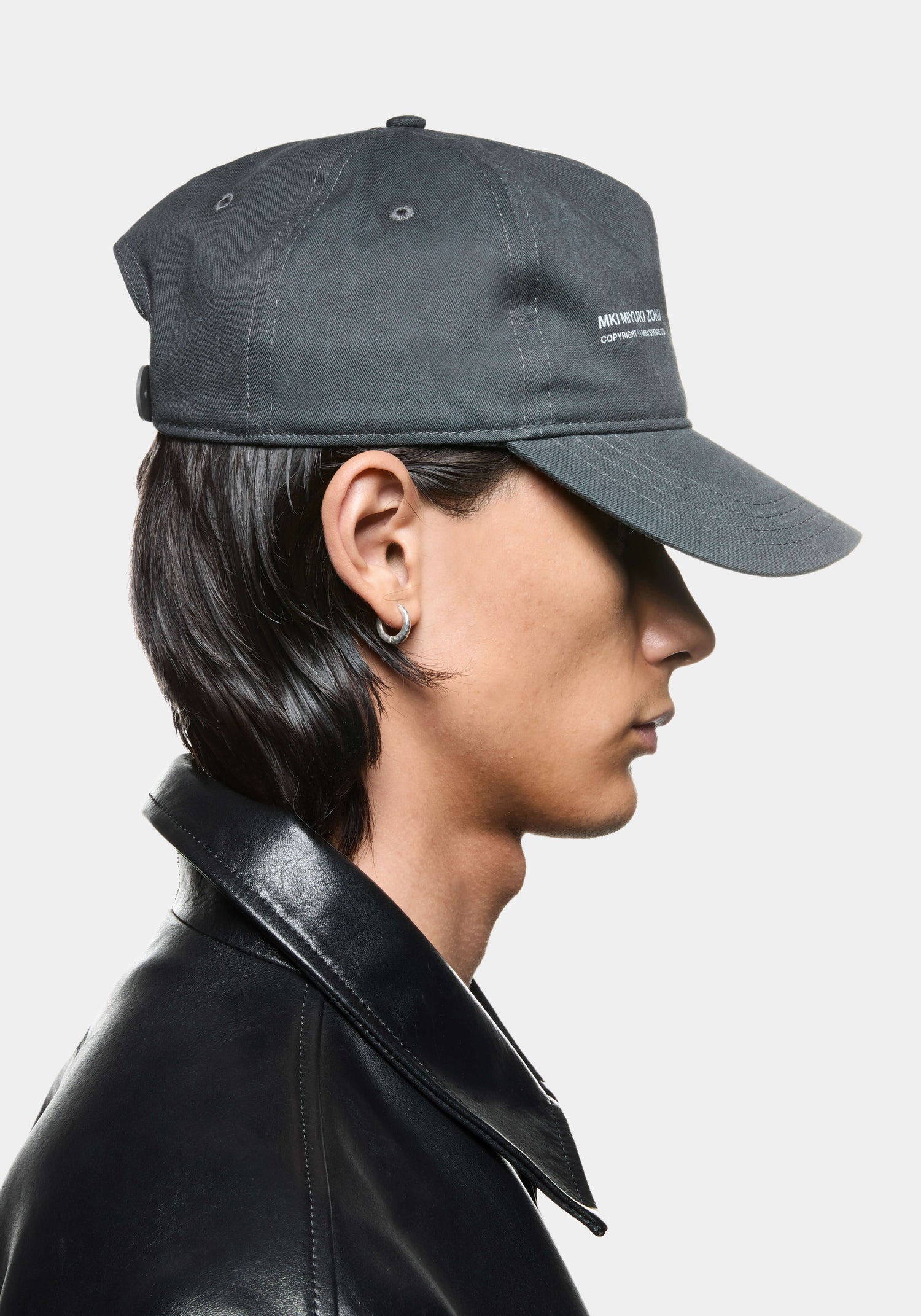 Side view of pigment black MKI Silhouette Cap featuring MKI Miyuki Zoku branding and snapback adjuster.