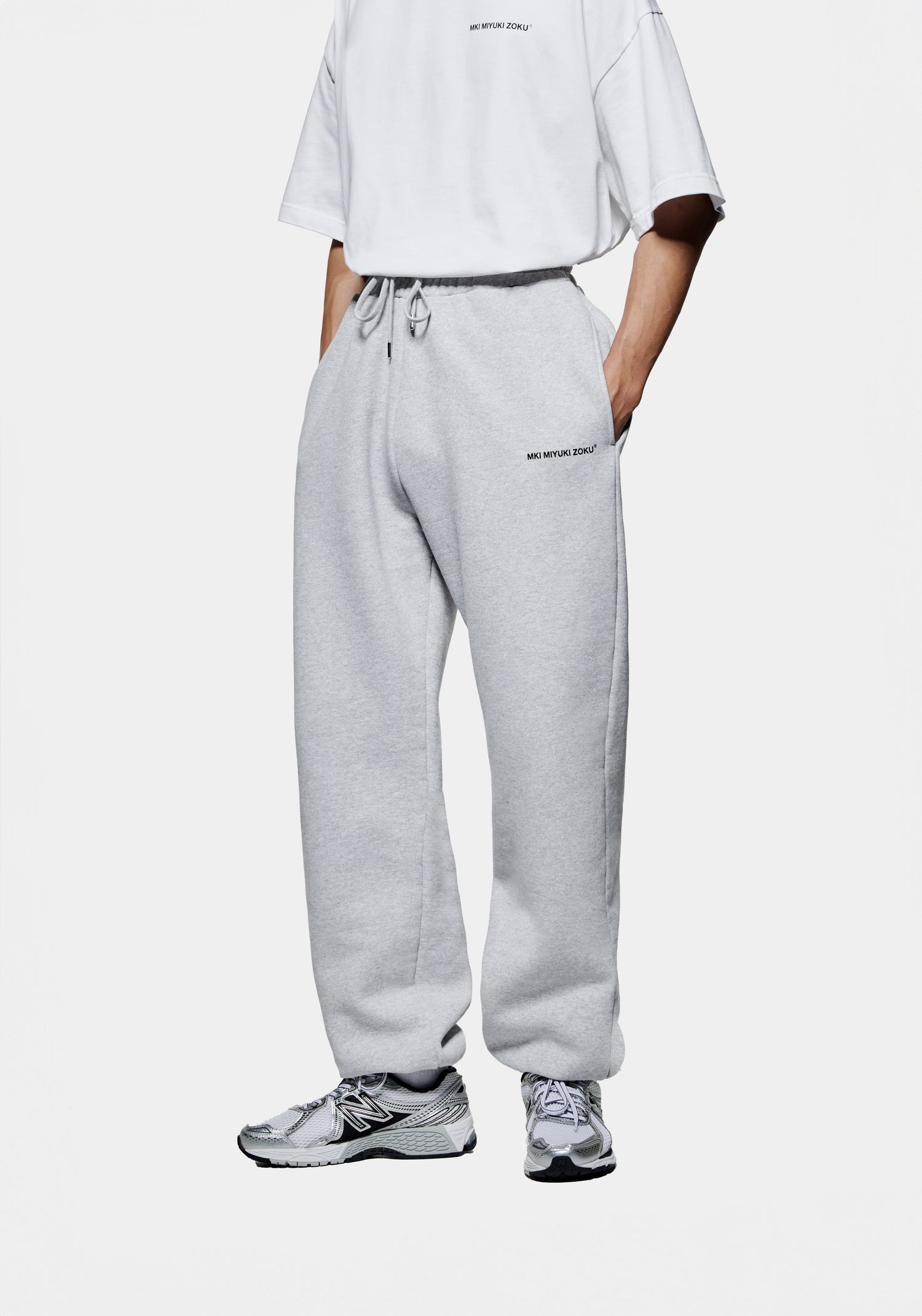 Front side view of the MKI men's baggy cuffed Uniform joggers in grey cotton jersey with minimal logo branding