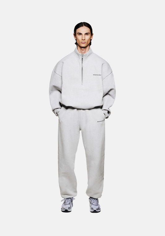 Front view of the MKI Uniform Jersey Quarter Zip Pullover Top in grey with black printed branding in a boxy oversized fit