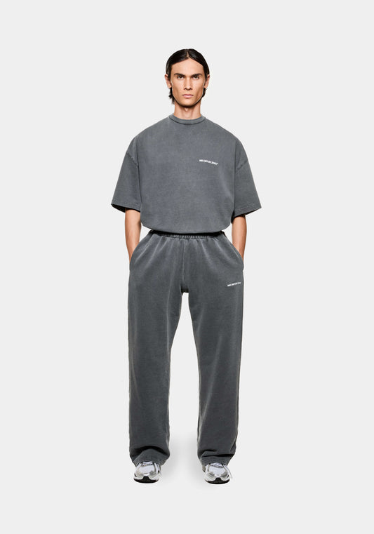 Front view of the MKI men's open hem Wide Leg joggers in pigment black cotton jersey with minimal logo branding