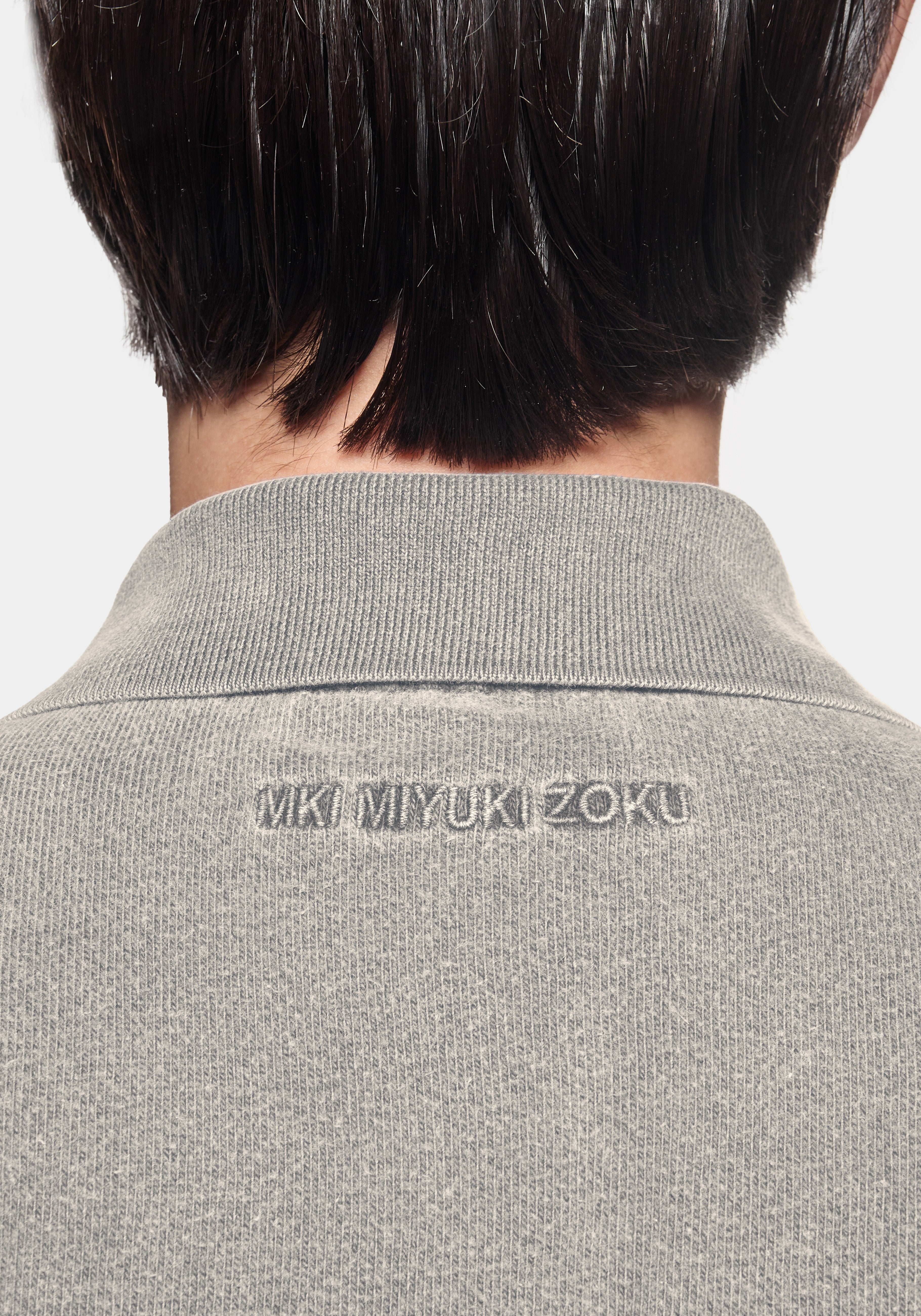 Close-up of the tonal MKI MIYUKI ZOKU logo embroidered at the back neck