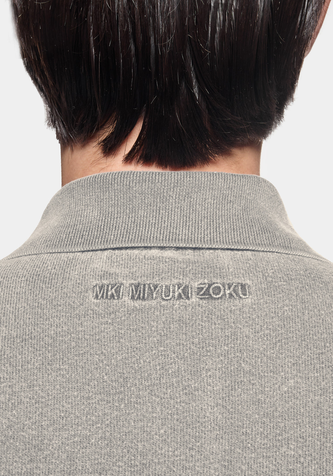 Close-up of the tonal MKI MIYUKI ZOKU logo embroidered at the back neck