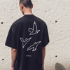 Person wearing a black t-shirt with white line art of three birds on the back